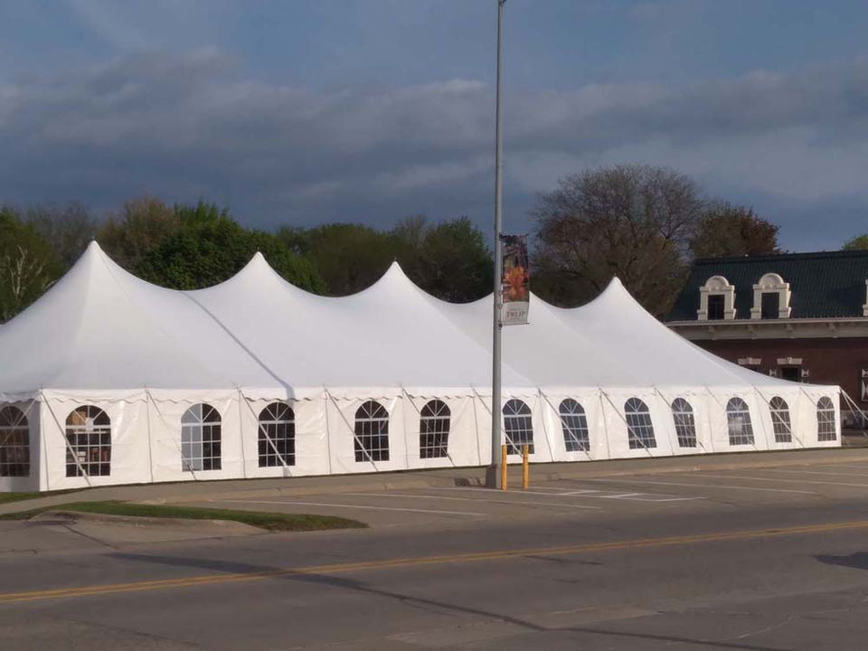 Beautiful wedding reception under a white tent with warm chandelier lighting